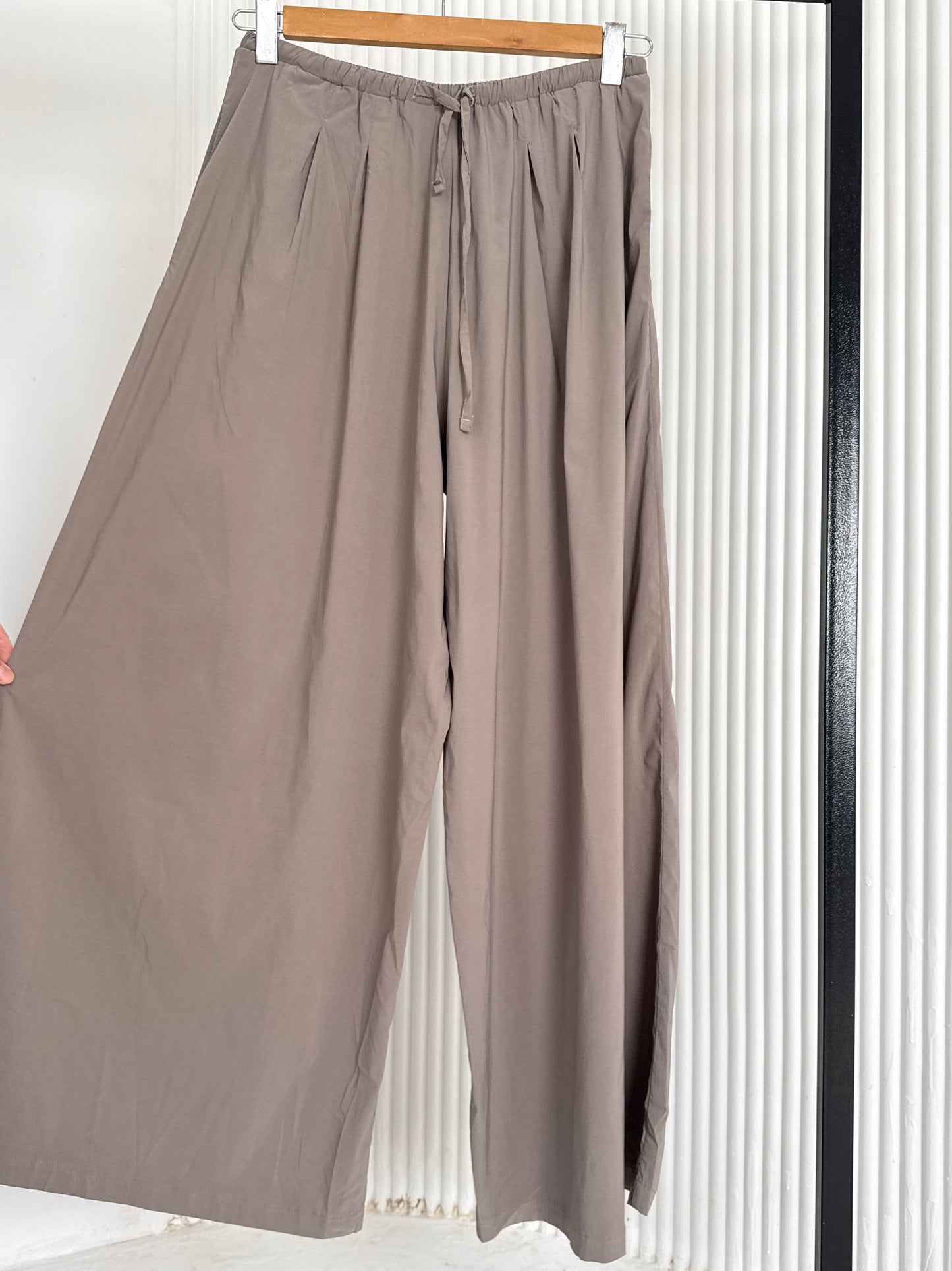 Amenaa wide leg pants with high waist and flowing fabric, shown on a model against a white background.