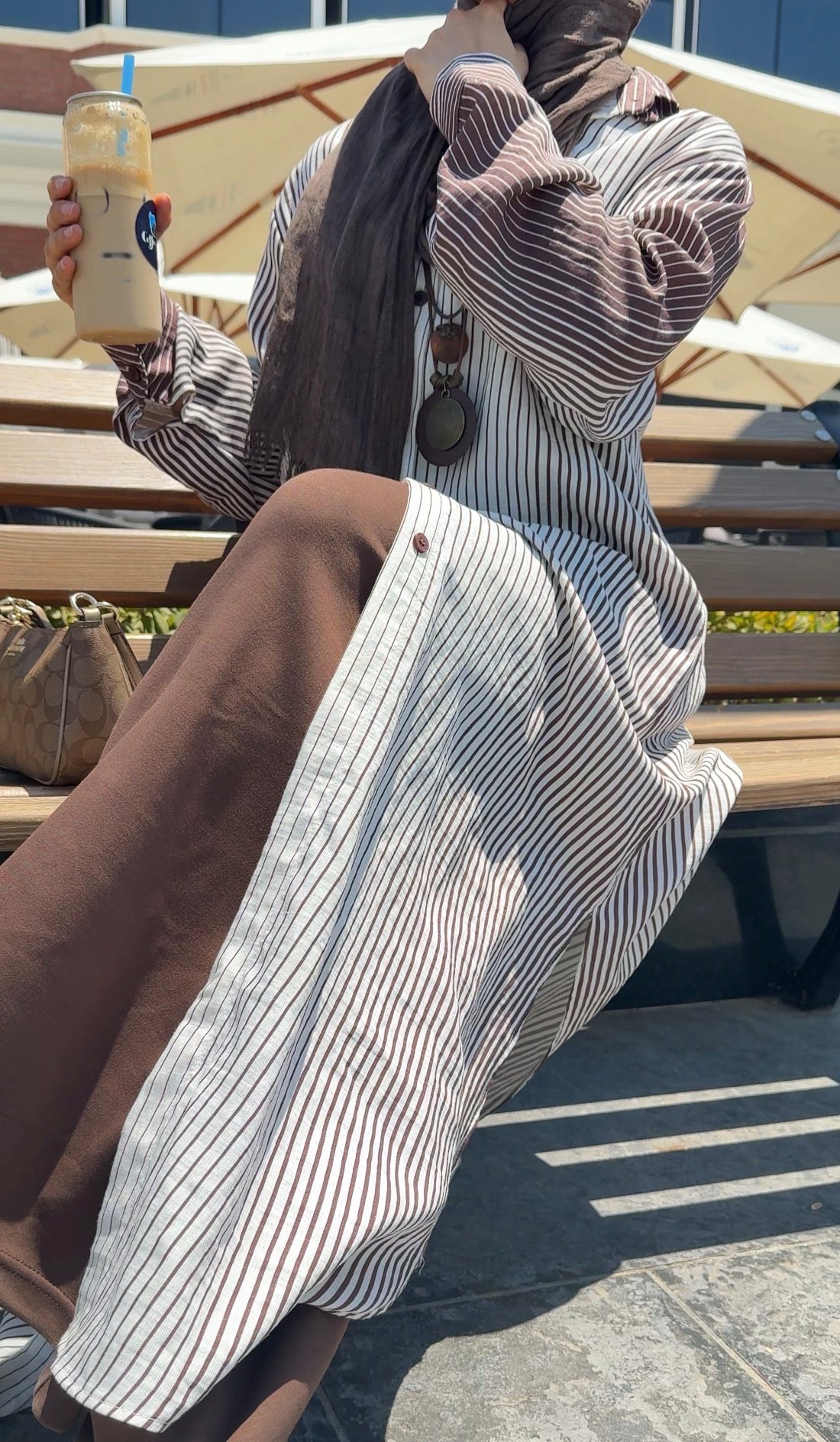 Amenaa long striped shirt featuring a relaxed fit with vertical blue and white stripes, displayed on a hanger.