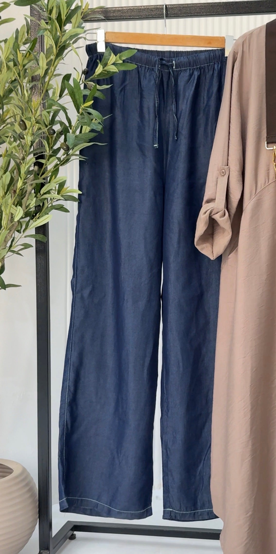 Amenaa tensile jeans shown in dark wash with classic five-pocket design and straight-leg fit.