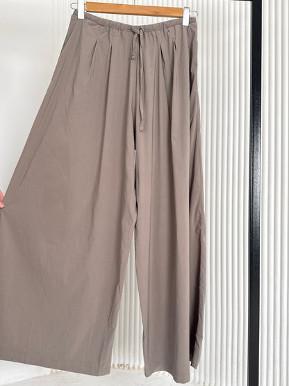 Amenaa wide leg pants with high waist and flowing fabric, shown on a model against a white background.