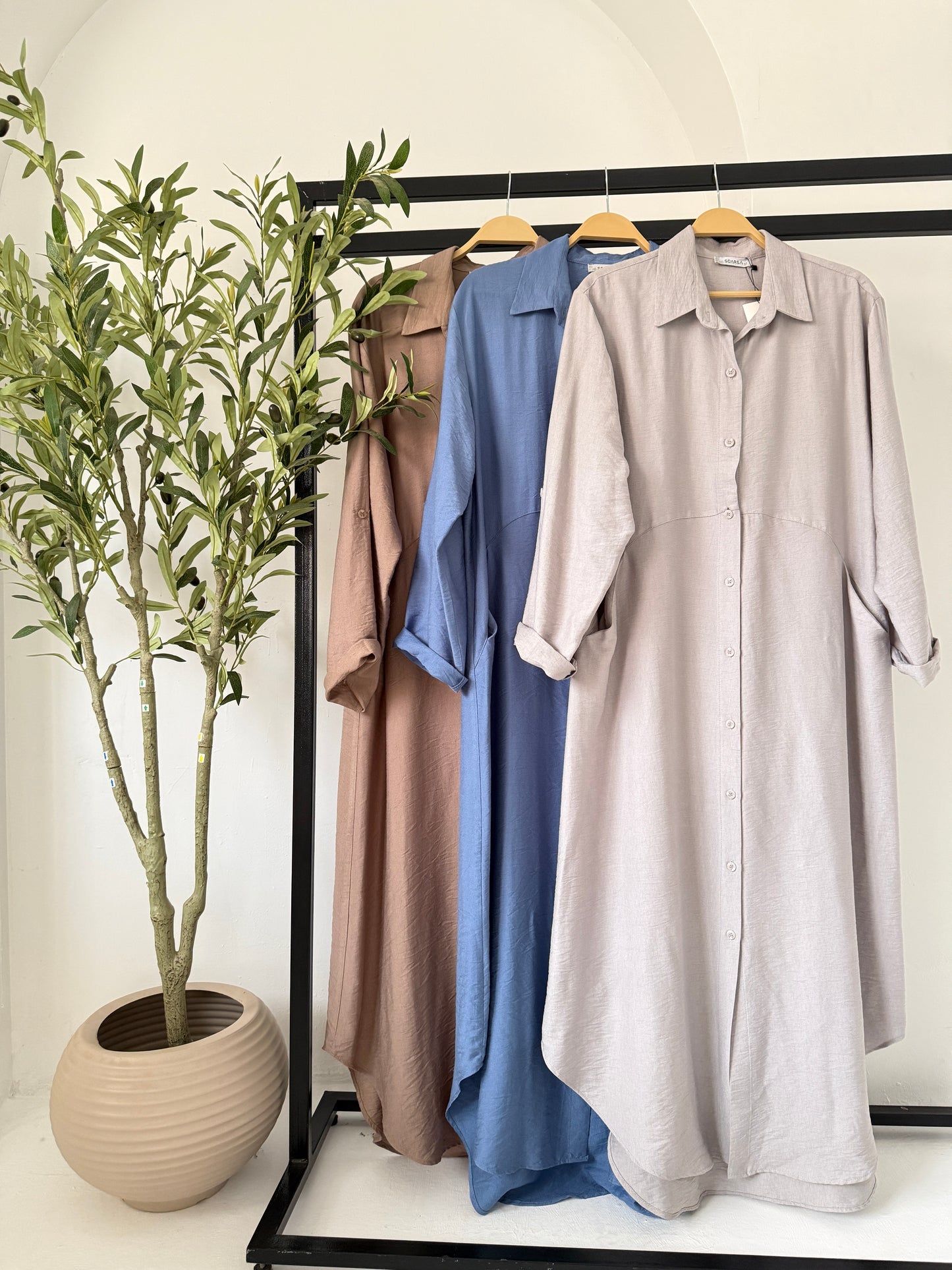 Grey Amenaa shirt dress hanging on a wooden hanger, showcasing a casual and stylish women's dress with a collar and button details.