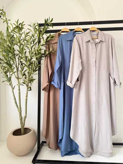 Grey Amenaa shirt dress hanging on a wooden hanger, showcasing a casual and stylish women's dress with a collar and button details.