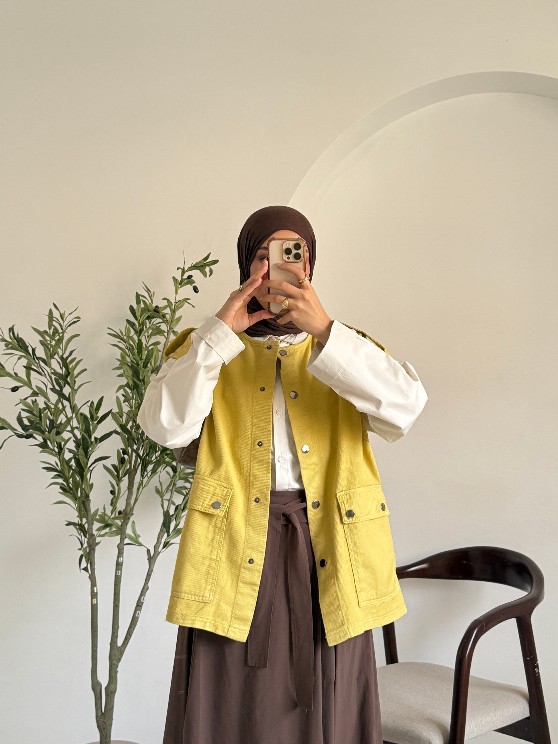 Amenaa gabardine vest displayed on a hanger, showcasing its tailored fit and classic design in neutral fabric.