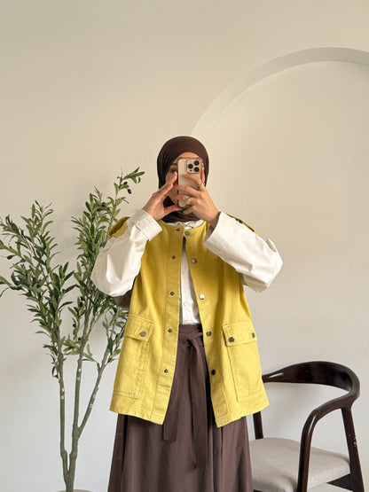 Amenaa gabardine vest displayed on a hanger, showcasing its tailored fit and classic design in neutral fabric.