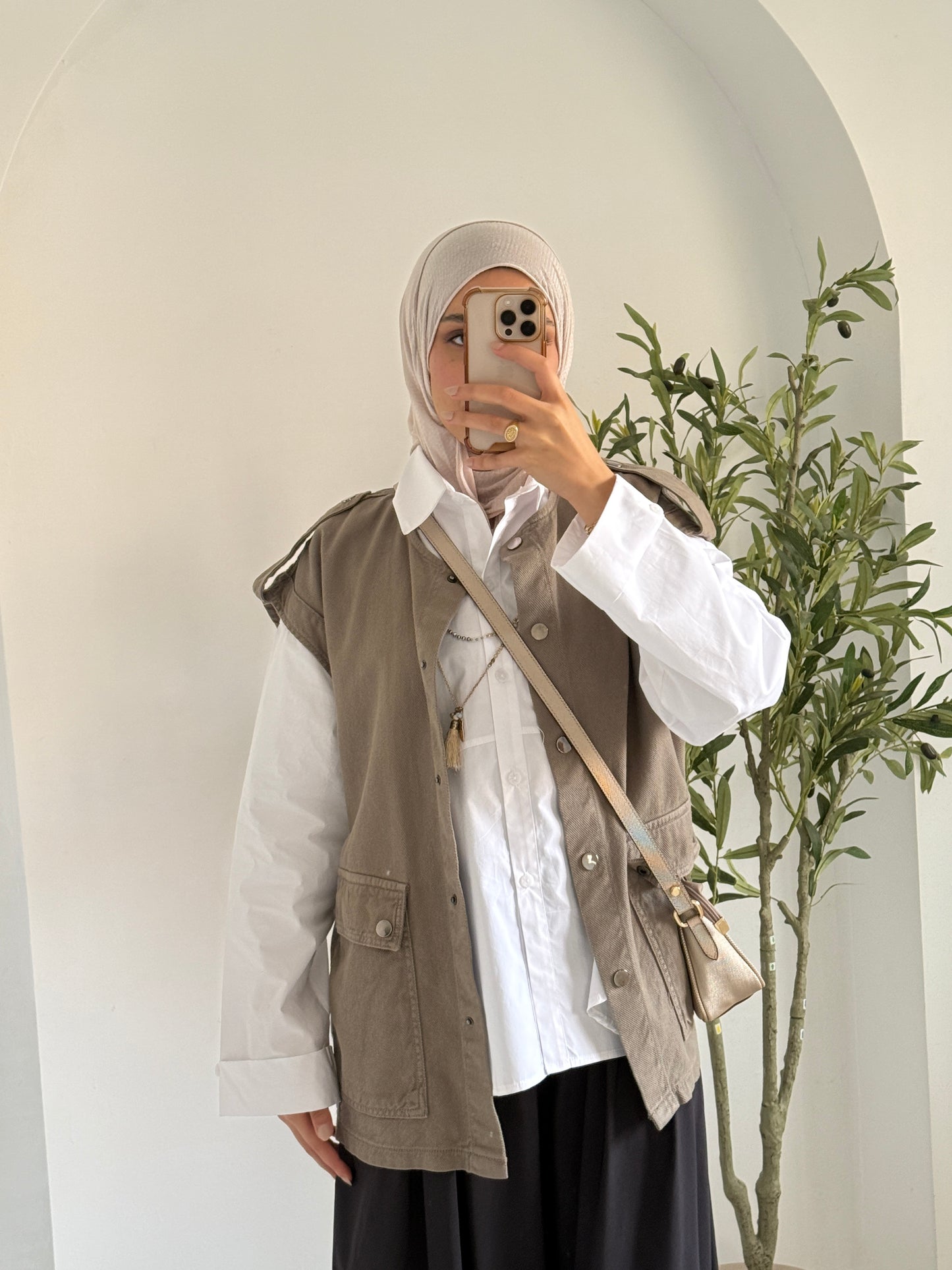 Amenaa new gabardine vest displayed on a hanger, featuring a tailored fit and classic design in neutral fabric.