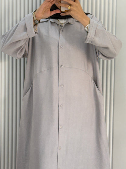 Grey Amenaa shirt dress hanging on a wooden hanger, showcasing a casual and stylish women's dress with a relaxed fit.
