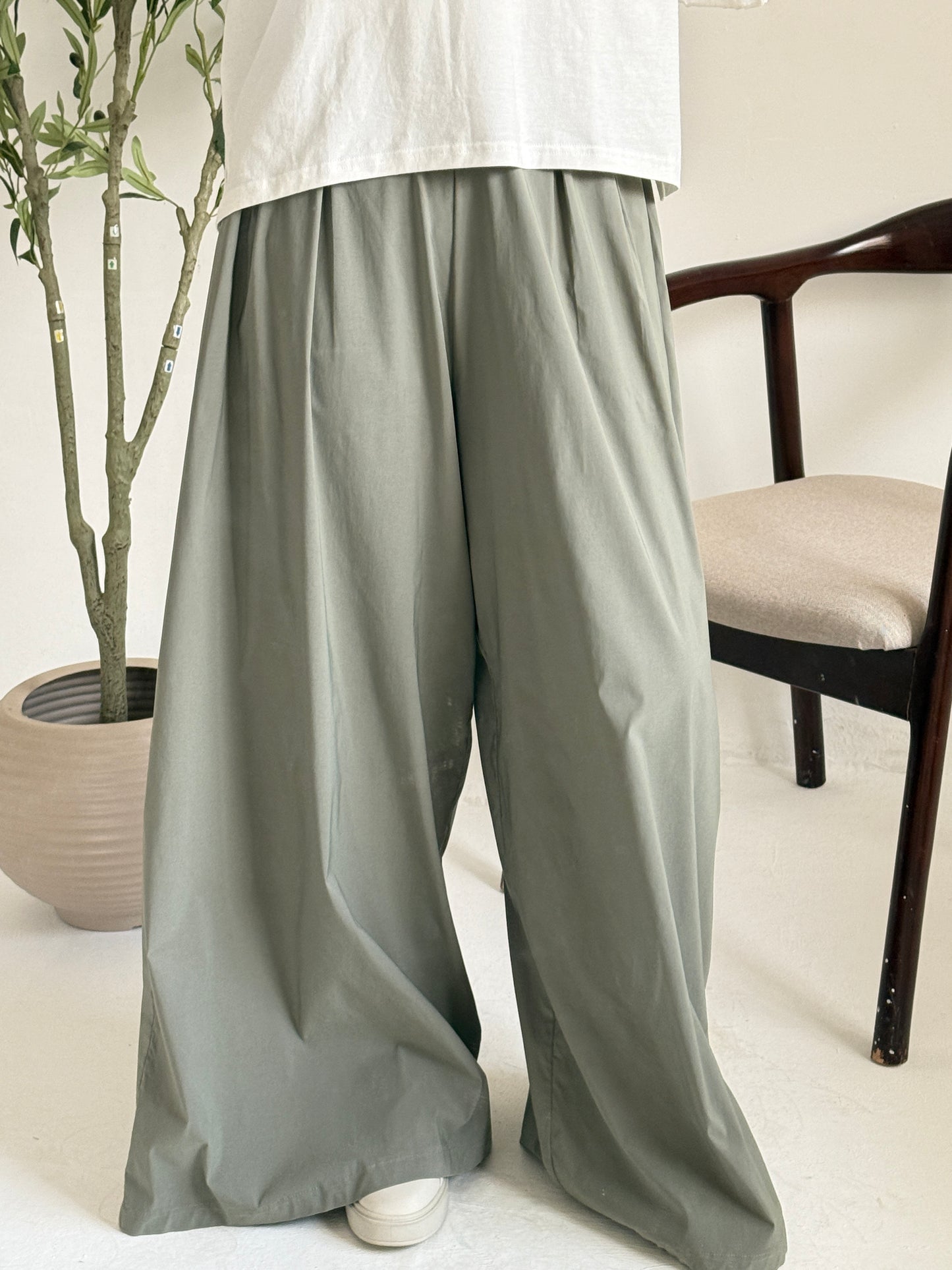Amenaa wide leg pants in beige fabric, featuring a relaxed fit and high waist, displayed laid flat.