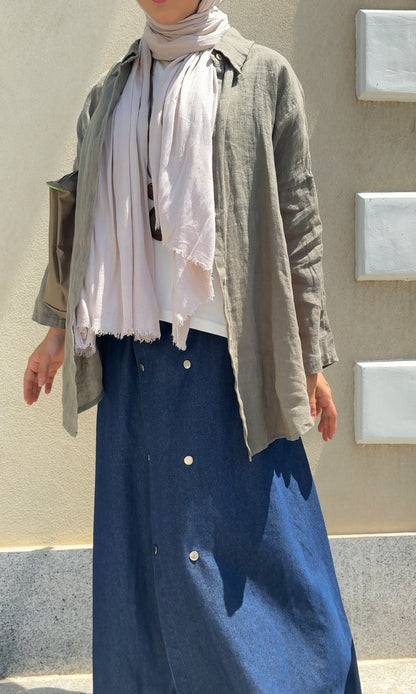 Amenaa linen shirt displayed on a hanger, featuring a light, breathable fabric with a classic collar and button-down front.