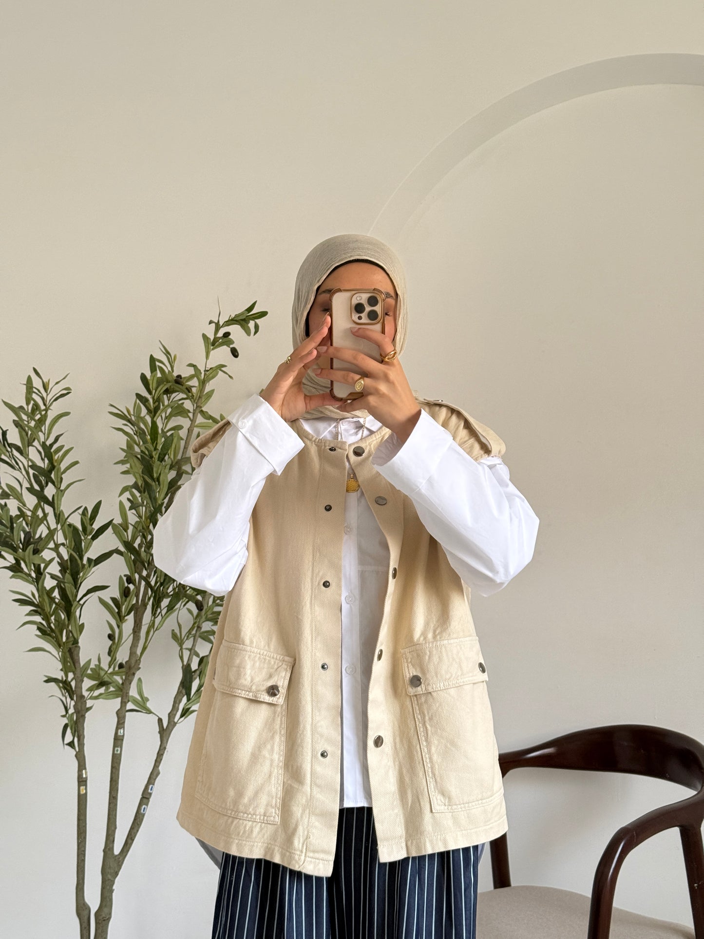 Amenaa new gabardine vest displayed on a hanger, showcasing its tailored fit and classic design in neutral color.