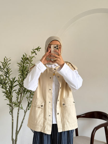 Amenaa new gabardine vest displayed on a hanger, showcasing its tailored fit and classic design in neutral color.