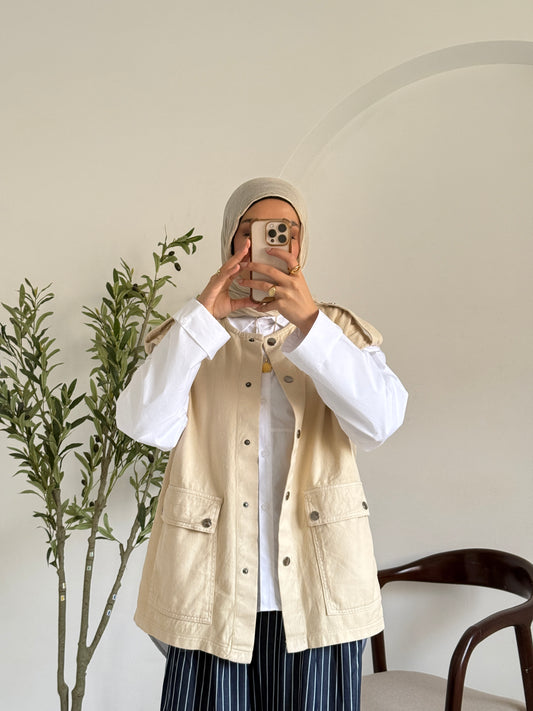Amenaa new gabardine vest displayed on a hanger, showcasing its tailored fit and classic design in neutral color.