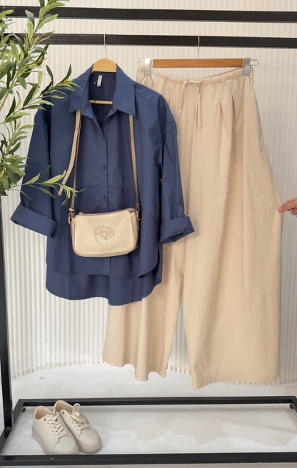 Amenaa oversized poplin shirt displayed flat, showing its relaxed fit, collar, and long sleeves on a neutral background.