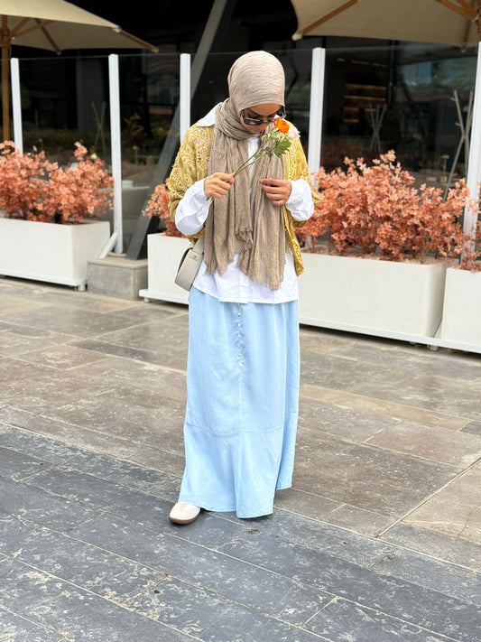 Light denim skirt by Amenaa, showing a close-up of the textured fabric and classic A-line silhouette.