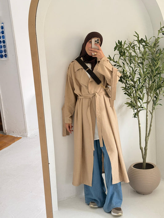 Amenaa summer trench coat in light fabric, shown on a hanger with a classic beige design and button details.