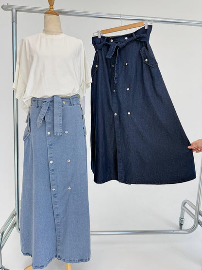 Amenaa button denim skirt shown hanging with front view, featuring metal buttons and classic blue denim fabric.