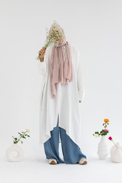Amenaa high-low shirt dress featuring a flowing design, with a collar, button front, and long sleeves on a model.