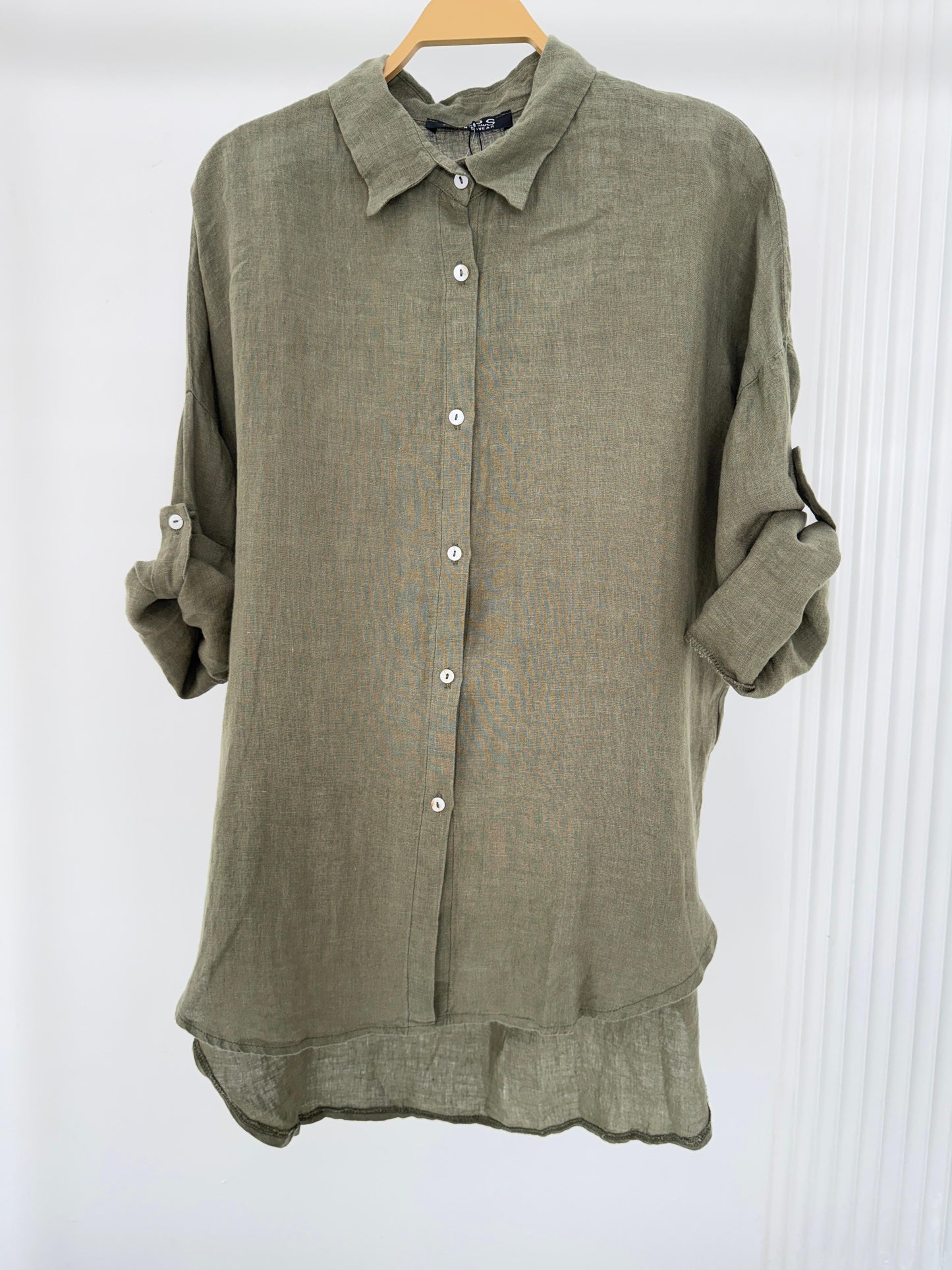 Amenaa linen shirt displayed on a hanger, showcasing lightweight, breathable fabric with a relaxed fit and classic collar.