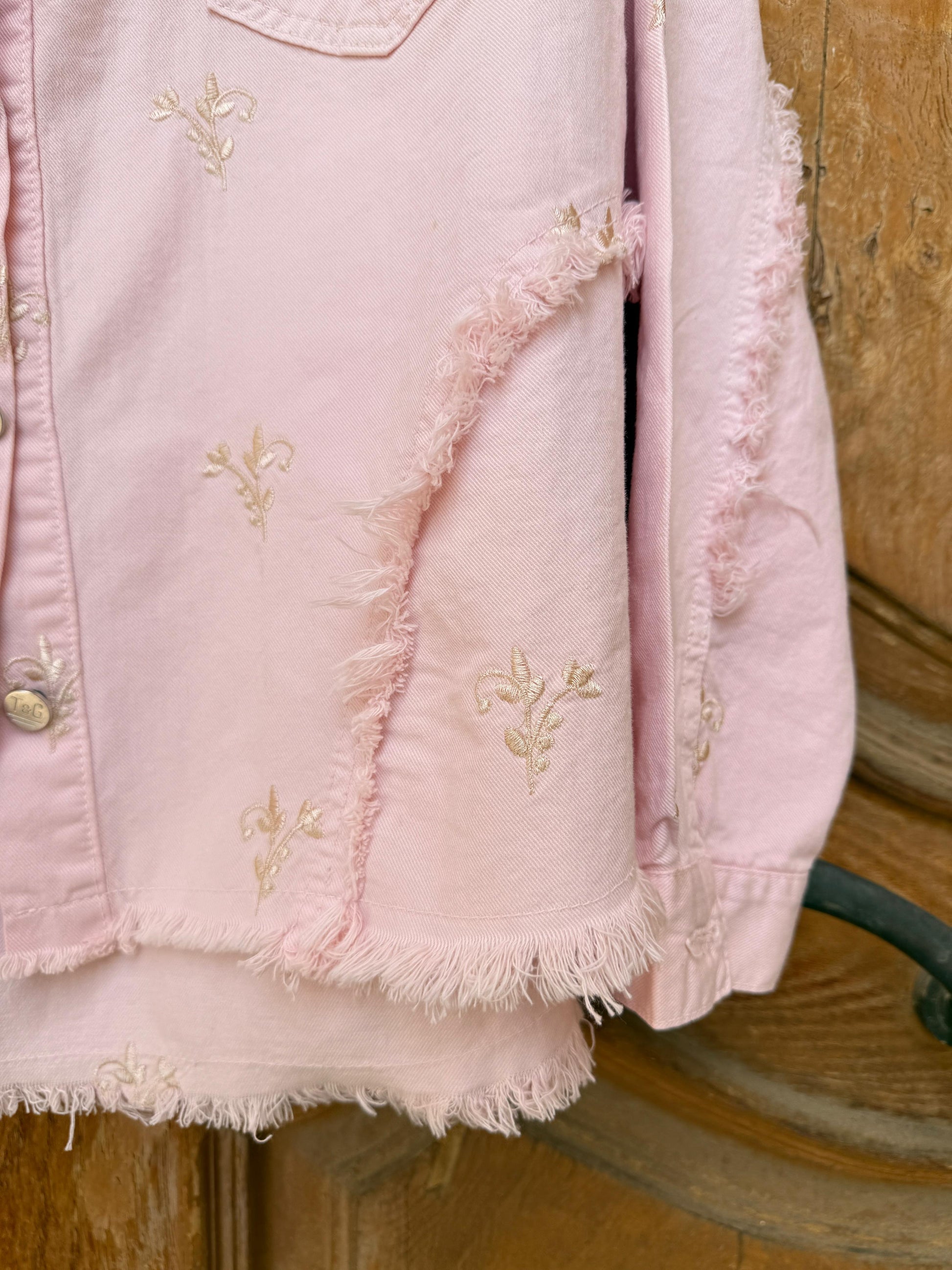 Flowery embroidered gabardine jacket by Amenaa featuring colorful floral patterns and tailored fit, displayed on a hanger.