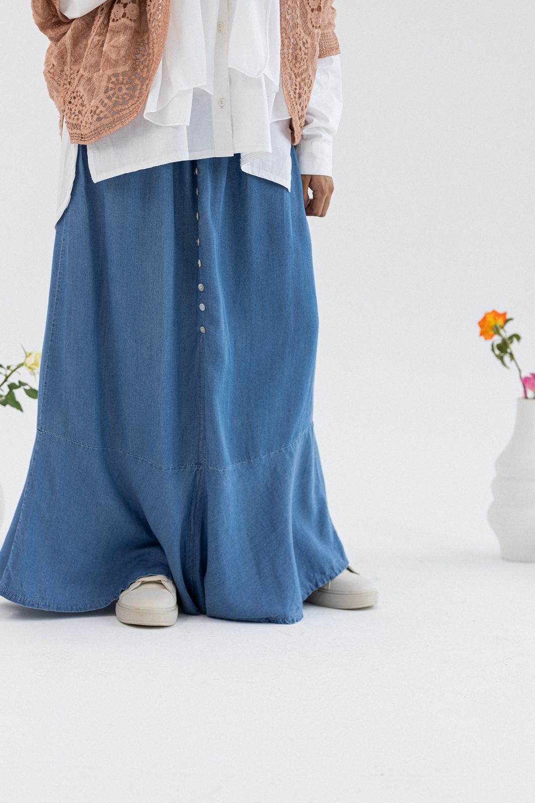 Light denim skirt by Amenaa, size 42, displayed on a hanger with visible stitching and classic five-pocket design.