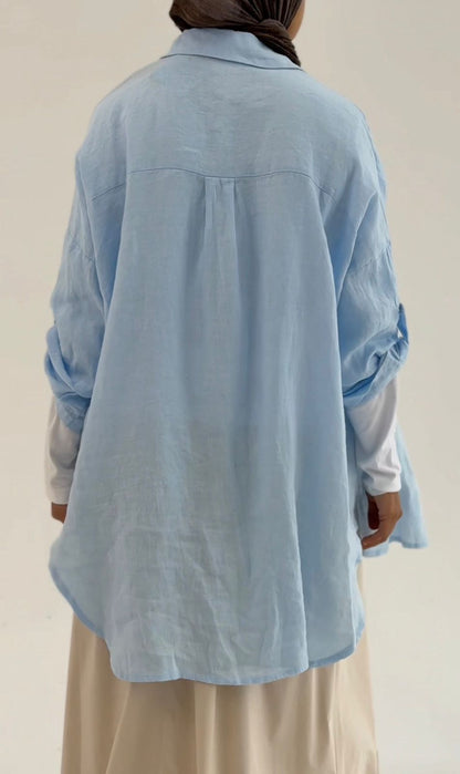 Light beige linen shirt by Amenaa displayed on a hanger, showcasing the relaxed fit and breathable fabric perfect for casual wear.