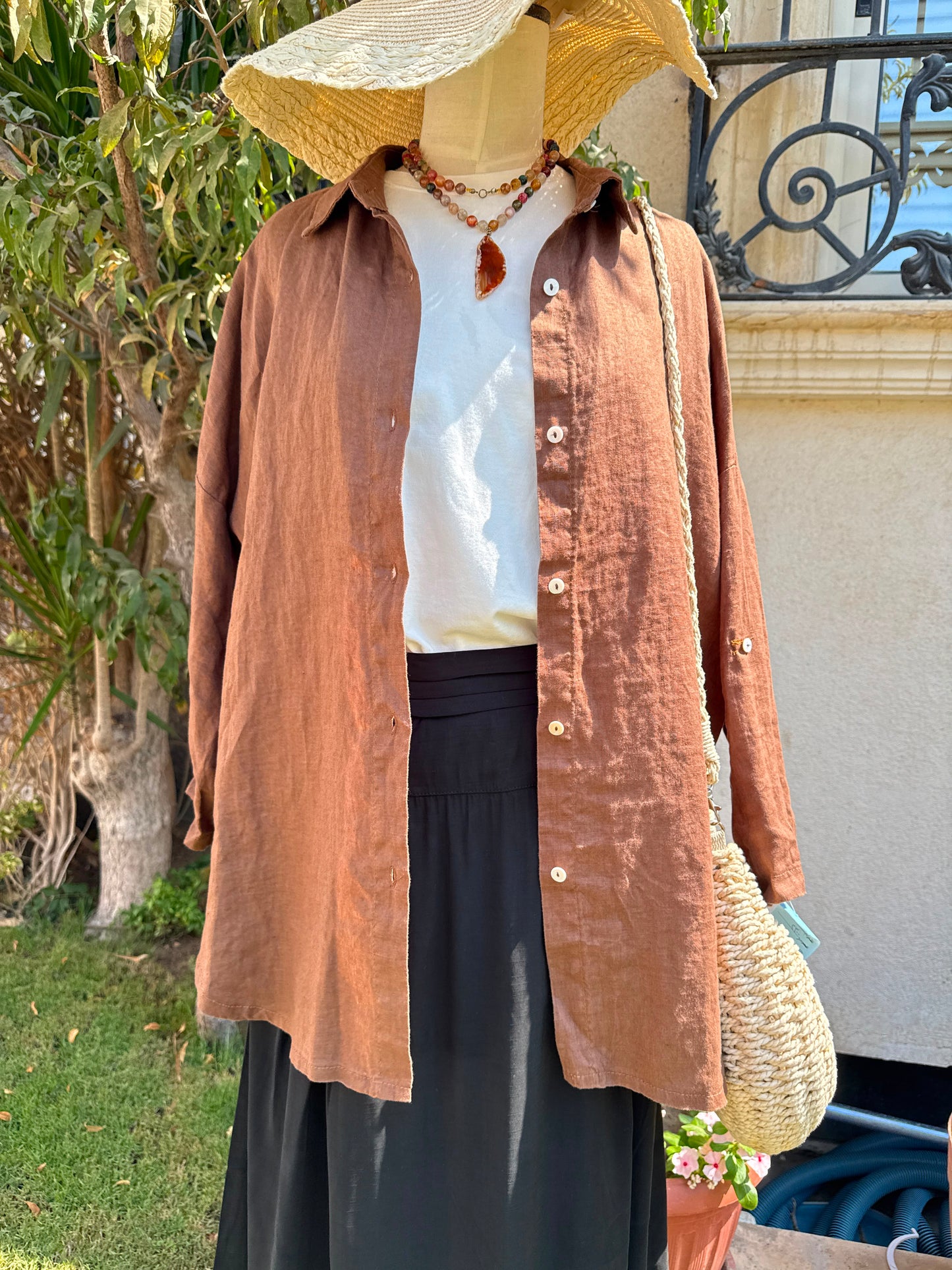 Men's linen shirt by Amenaa, light and breathable fabric with a relaxed fit, displayed on a hanger.