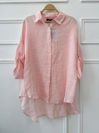 Light beige Amenaa linen shirt displayed on a hanger, showcasing its relaxed fit and breathable fabric.