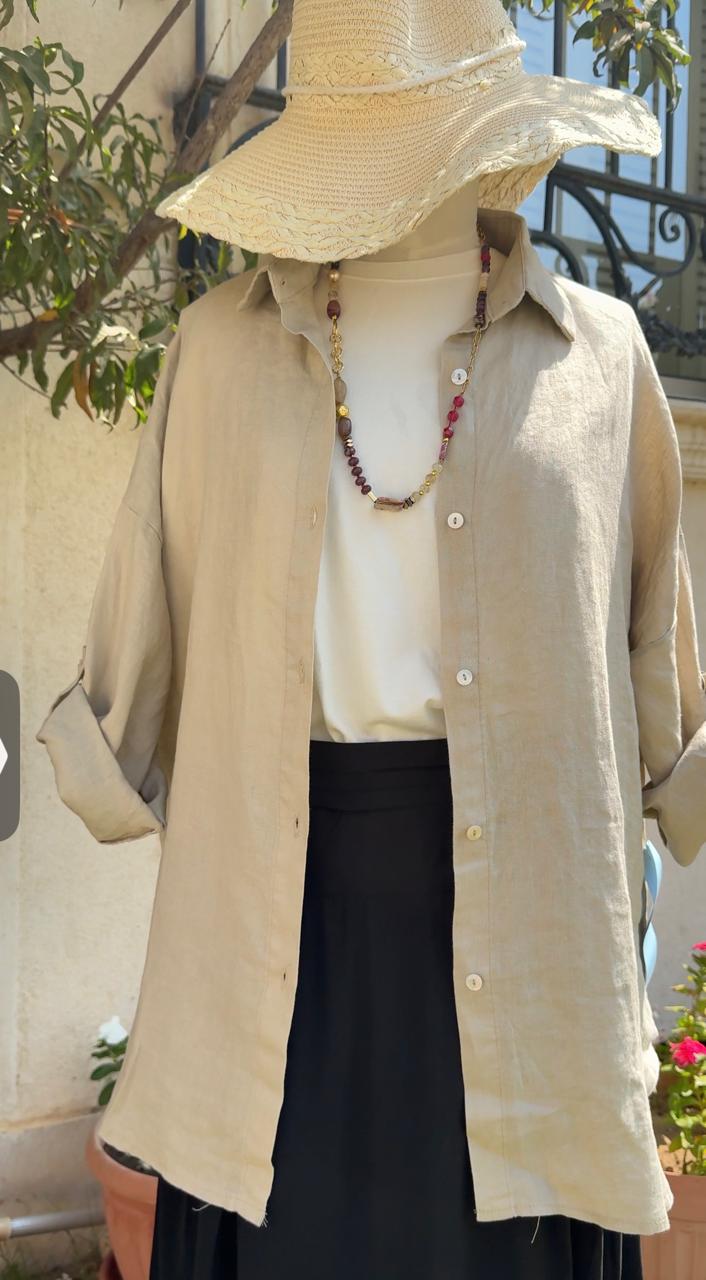 Light beige linen shirt by Amenaa with a relaxed fit, featuring a classic collar and button front, styled casually on a model.