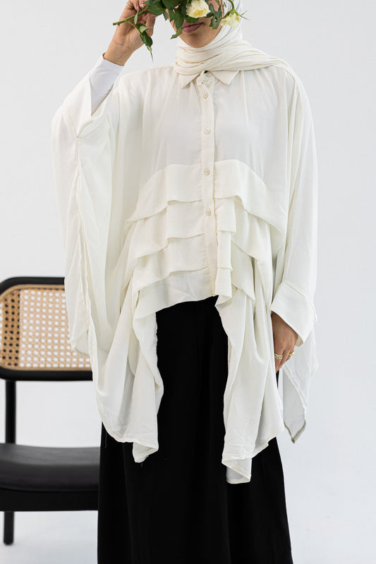 Amenaa ruffles blouse with delicate ruffle details and long sleeves, displayed on a hanger.
