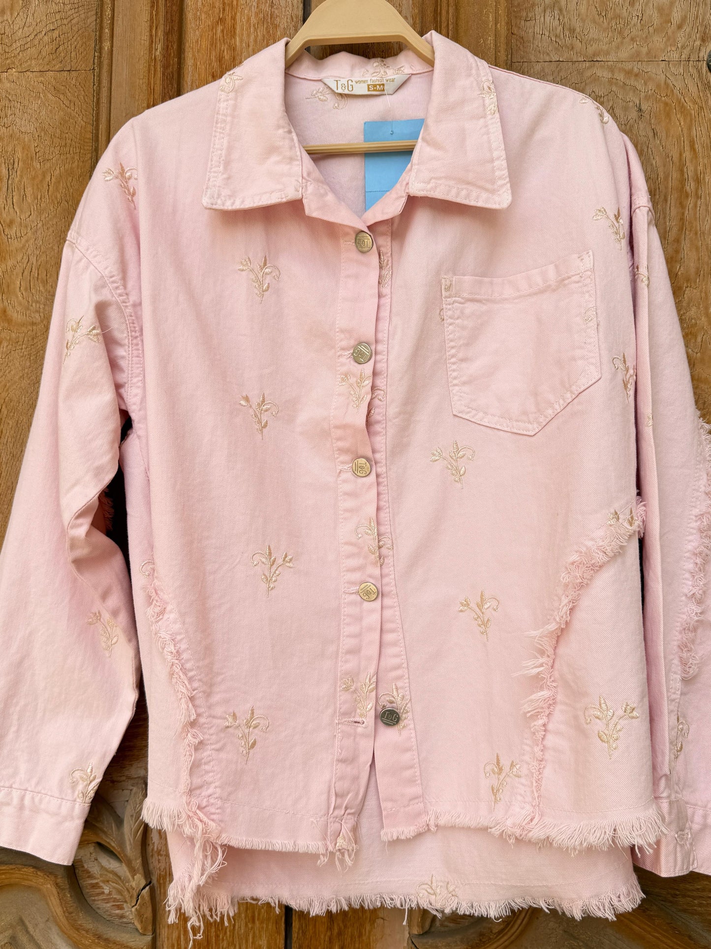 Amenaa flowery embroidered gabardine jacket with vibrant floral patterns and tailored fit, displayed on a hanger.