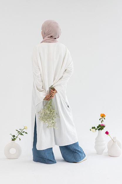 Amenaa high-low shirt dress featuring a flowing silhouette and collar, shown in a stylish, casual wear setting.