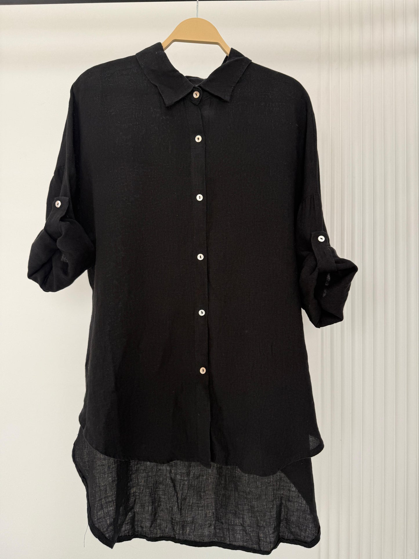 Amenaa linen shirt displayed on a hanger, featuring lightweight, breathable fabric with a classic collar and button-up front.