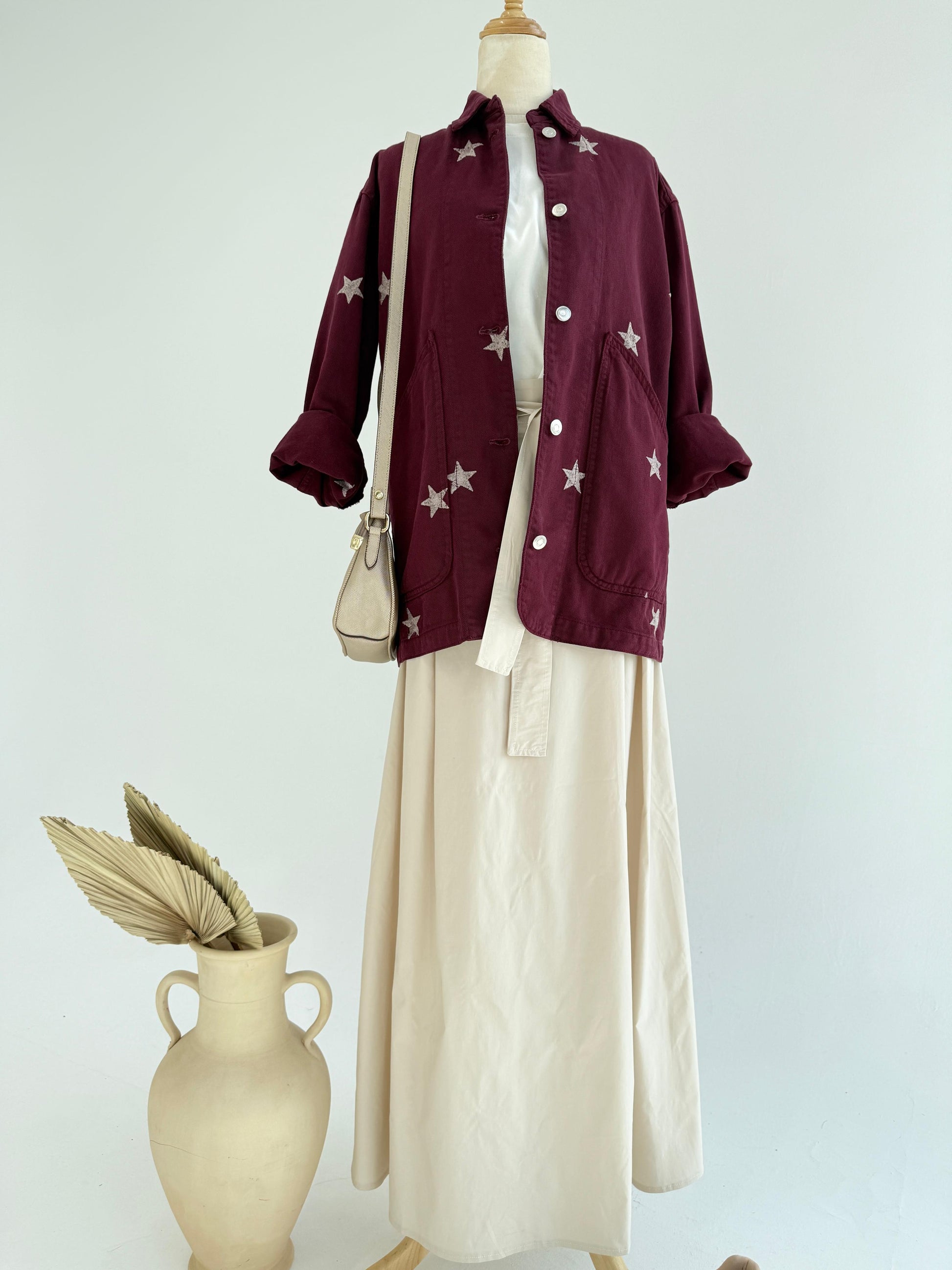 Amenaa Star Gabardine Jacket displayed on a hanger, showcasing its stylish design and fabric texture.