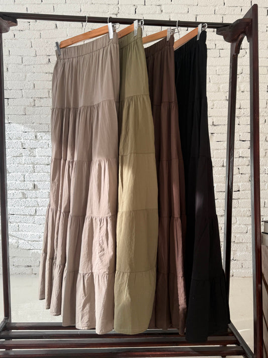 Amenaa flowy skirt with lightweight, breezy fabric and a relaxed fit, shown hanging on a wooden hanger.