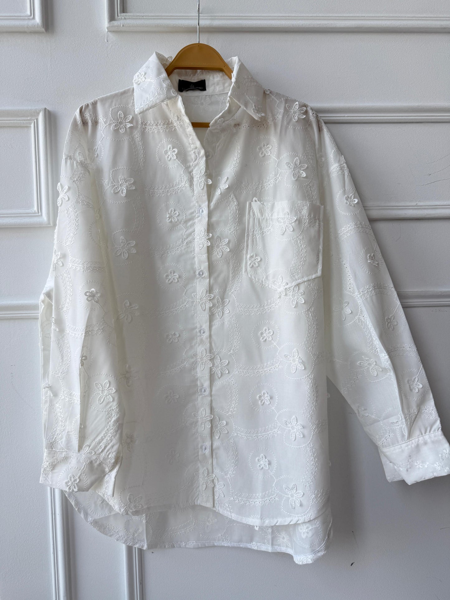 Floral embroidered Amenaa shirt with detailed colorful flower patterns on soft fabric, displayed on a hanger.