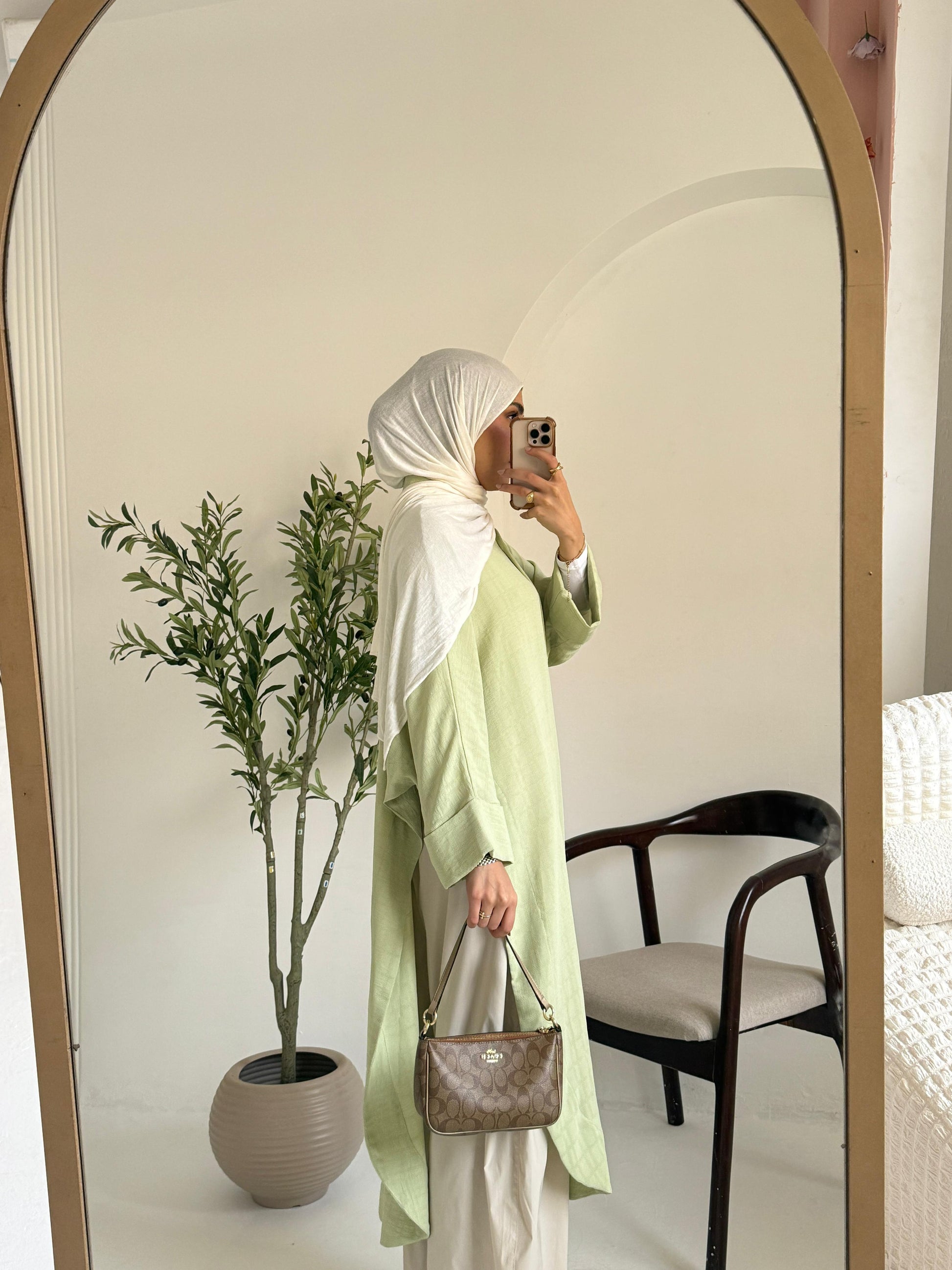 Amenaa textured oversized shirt dress hanging on a wooden hanger, showcasing a relaxed fit with a textured fabric and collar detail.