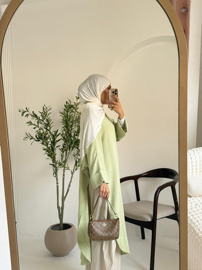 Amenaa textured oversized shirt dress hanging on a wooden hanger, showcasing a relaxed fit with a textured fabric and collar detail.
