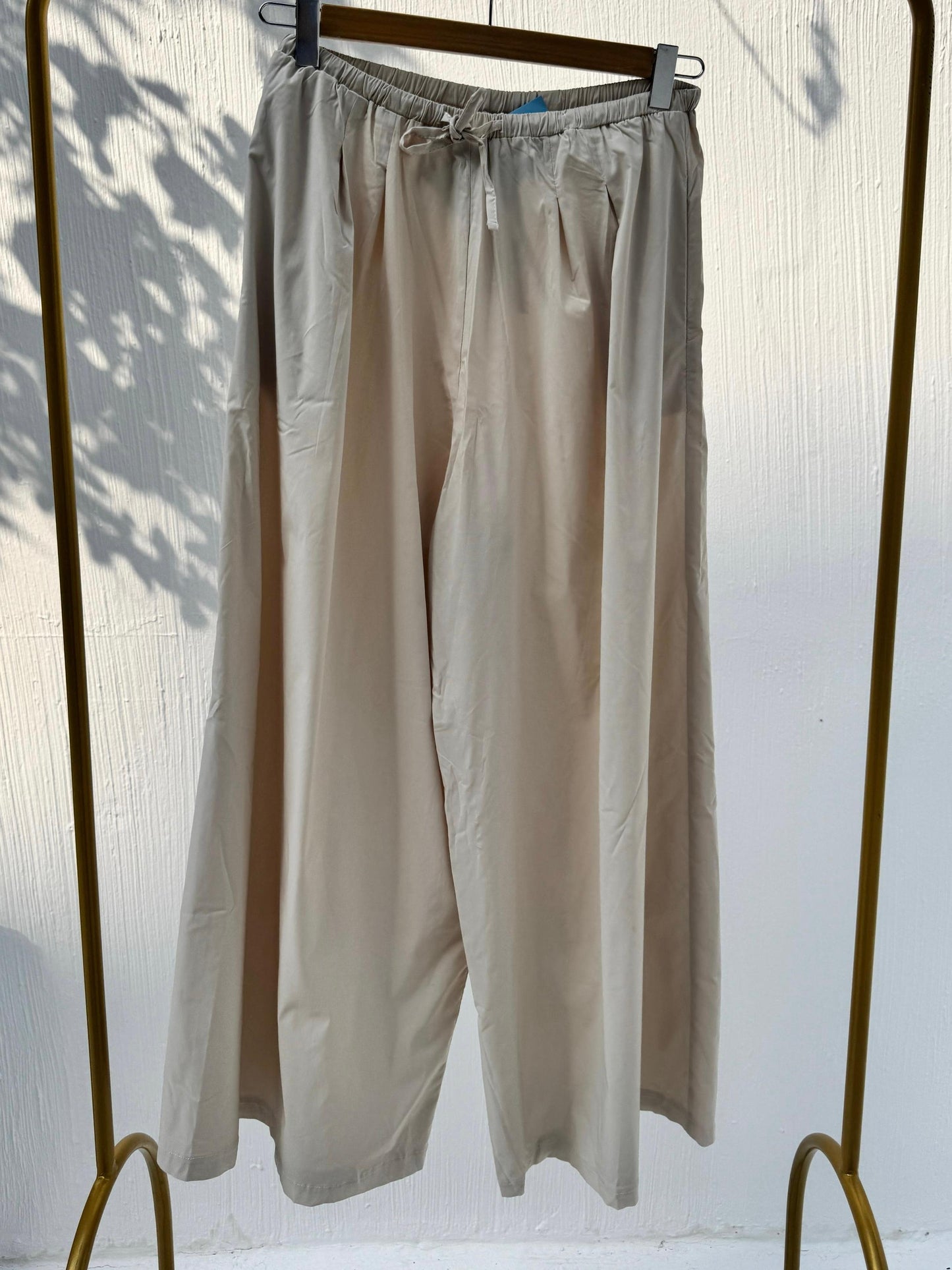 Amenaa wide leg pants in lightweight fabric, featuring a relaxed fit and high waist, styled with a casual top.