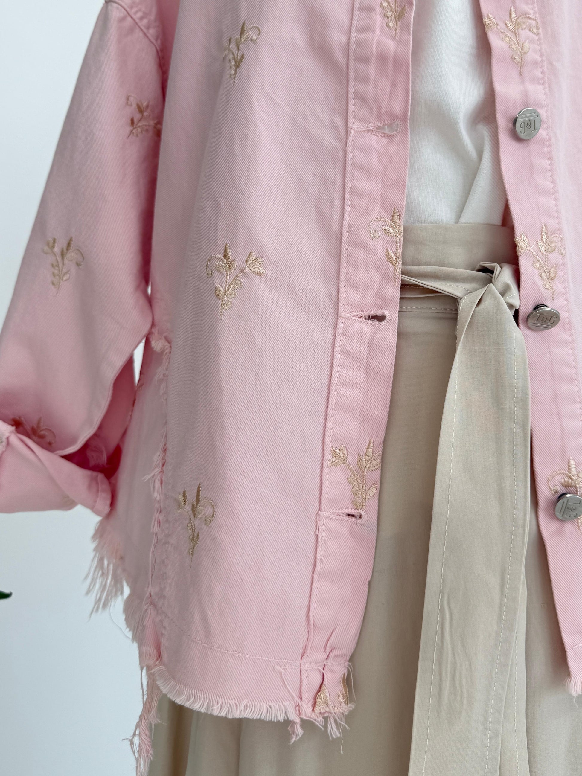 Flowery embroidered gabardine jacket by Amenaa featuring colorful floral embroidery and tailored fit, displayed on a hanger.