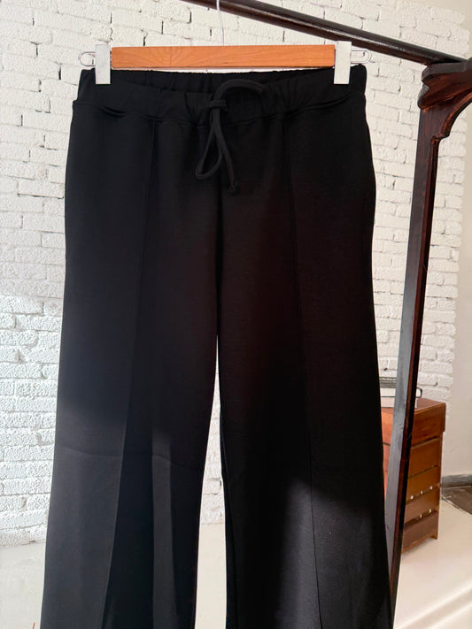 Black Amenaa Melton pants with a tailored fit, featuring a smooth fabric and classic design, displayed on a neutral background.