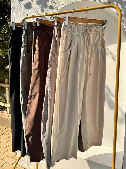 Amenaa balloon pants in beige with a relaxed fit, featuring a high waist and wide legs, shown on a model.