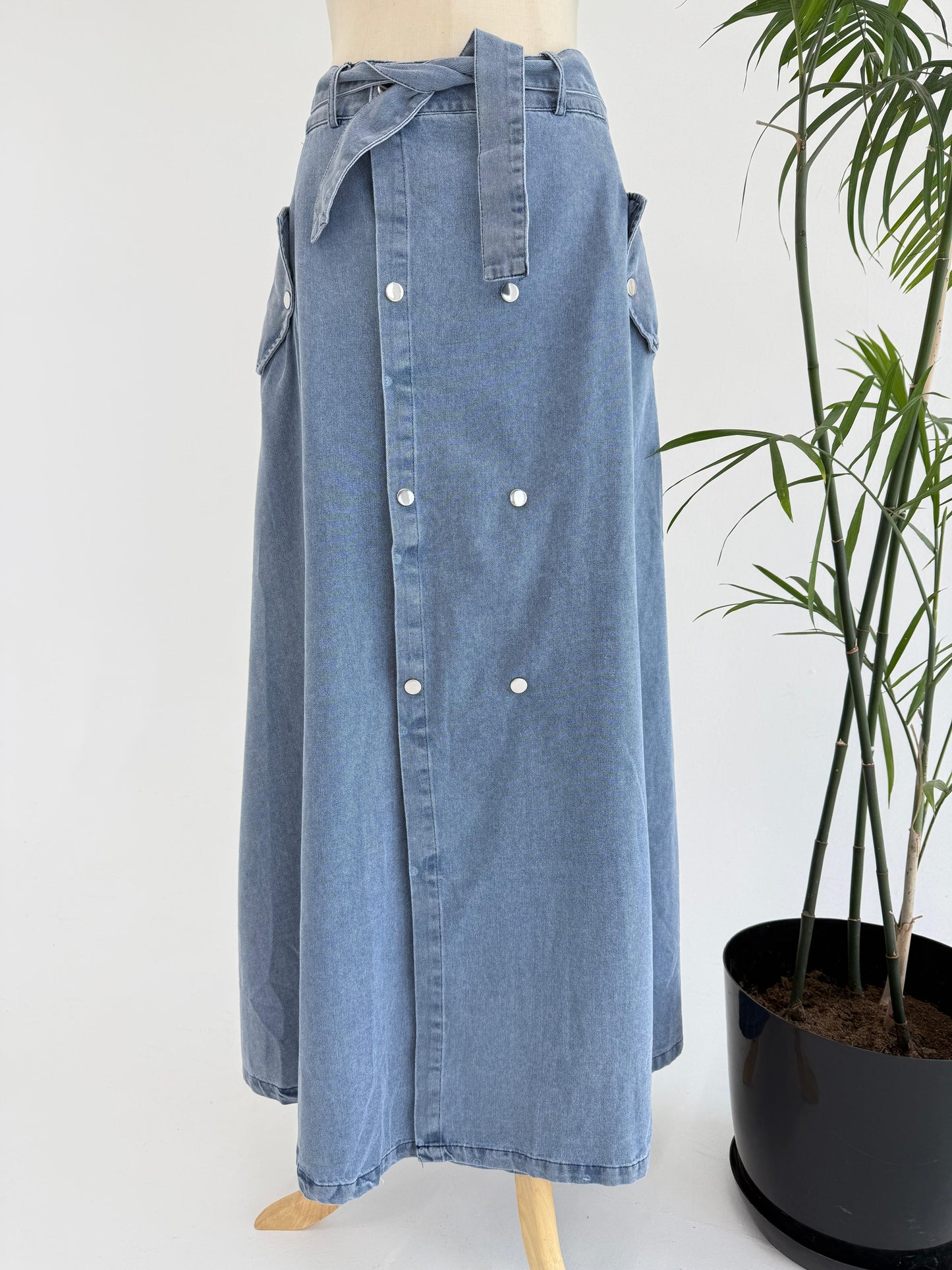 Amenaa button denim skirt with front pockets and waistband, styled with casual top and belt for a trendy look.