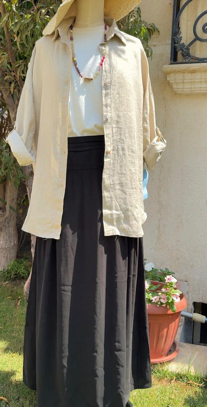 Light beige Amenaa linen shirt displayed on a hanger, showcasing its relaxed fit and soft, breathable fabric.
