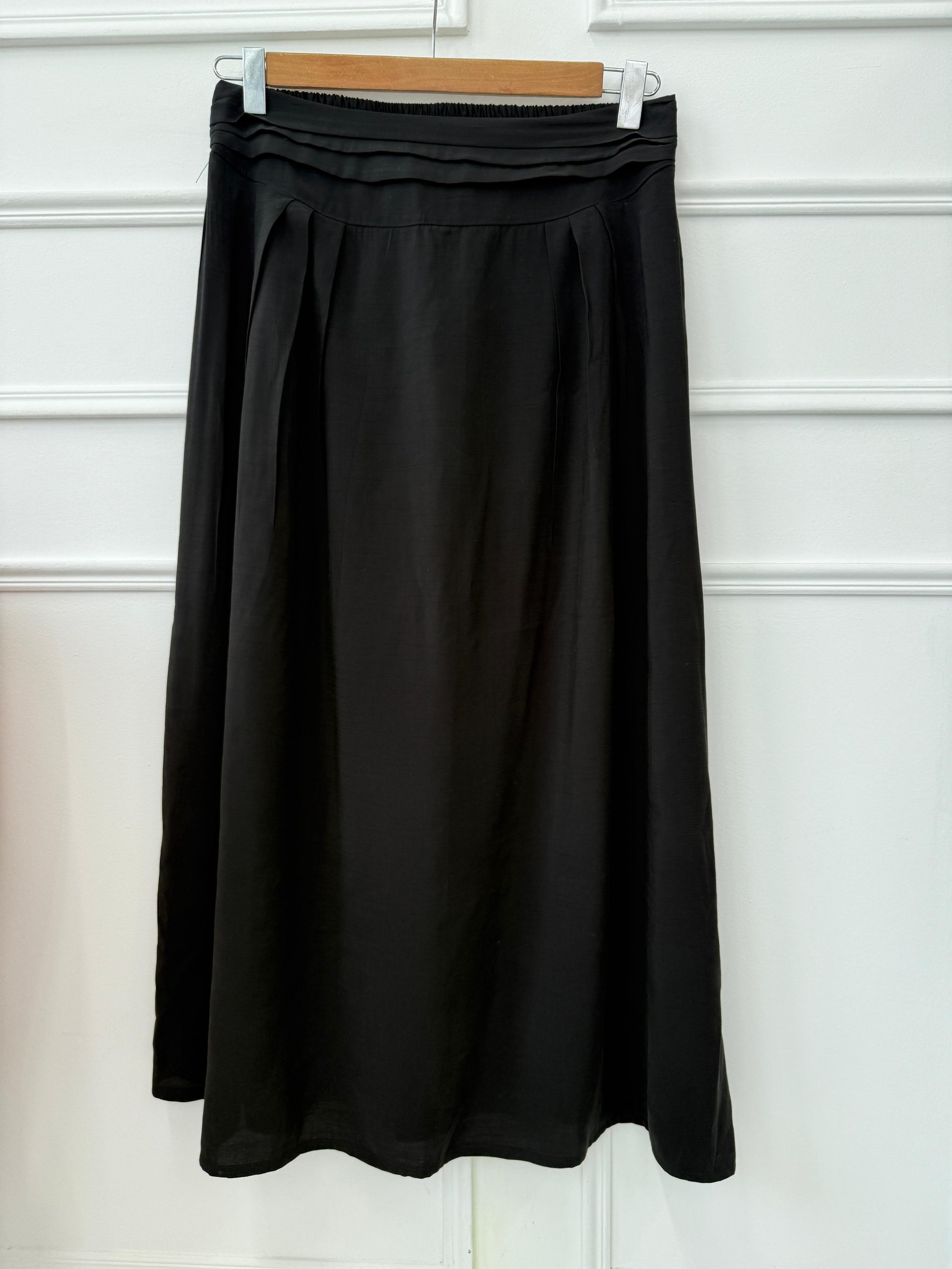 Light blue Amenaa skirt with a high waist and flowing fabric, shown on a model in a casual outdoor setting.