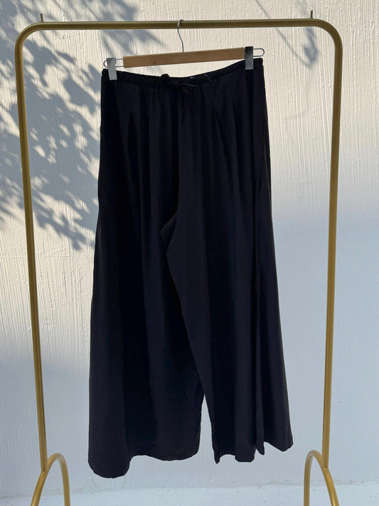 Amenaa wide leg pants featuring a relaxed fit, high waist, and flowing fabric, styled for casual or chic occasions.