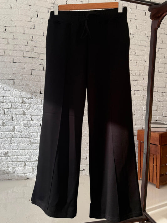 Amenaa Melton pants shown in dark fabric with a tailored fit, featuring side pockets and a classic design.