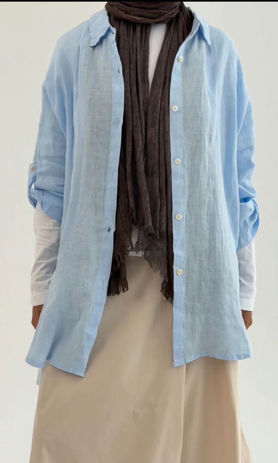 Amenaa linen shirt displayed on a hanger, featuring a light, breathable fabric with a relaxed fit and natural color.