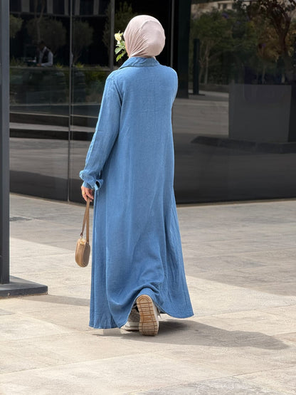 Amenaa maxi denim dress displayed on a hanger, featuring a flowing design with adjustable straps and classic denim fabric.