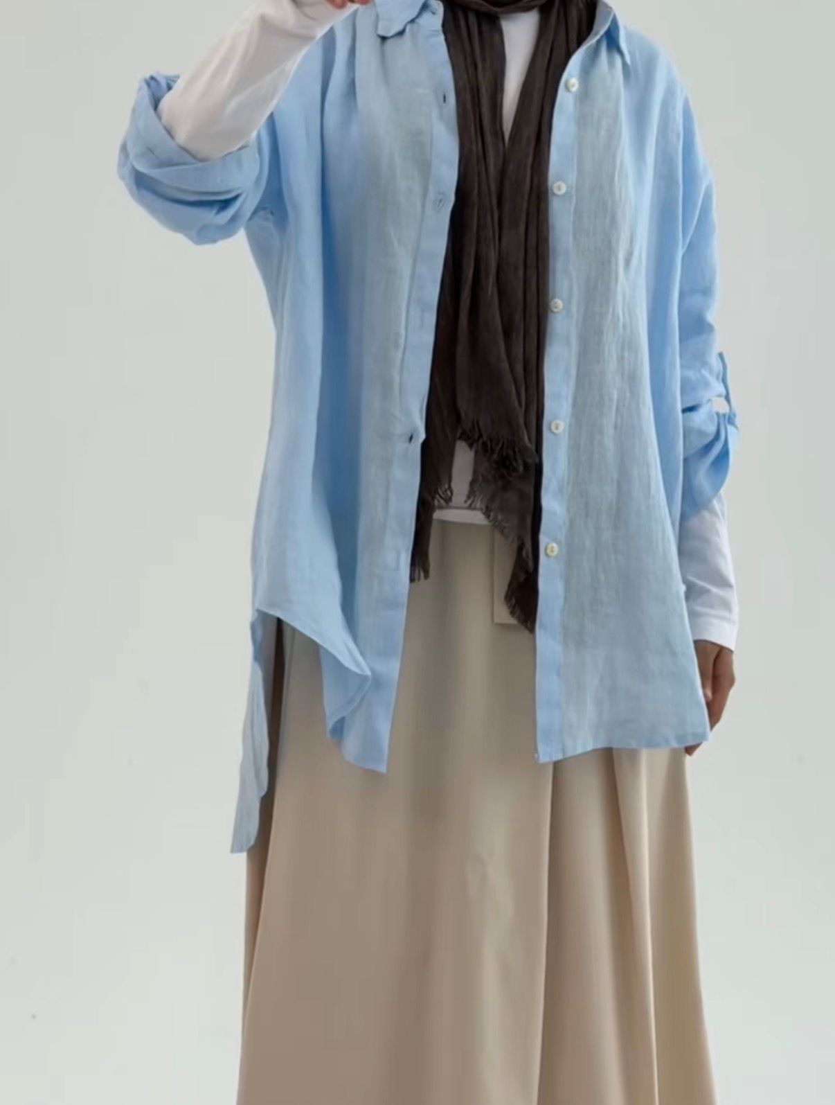 Amenaa linen shirt featuring a relaxed fit with long sleeves and a button-front design, displayed on a hanger.