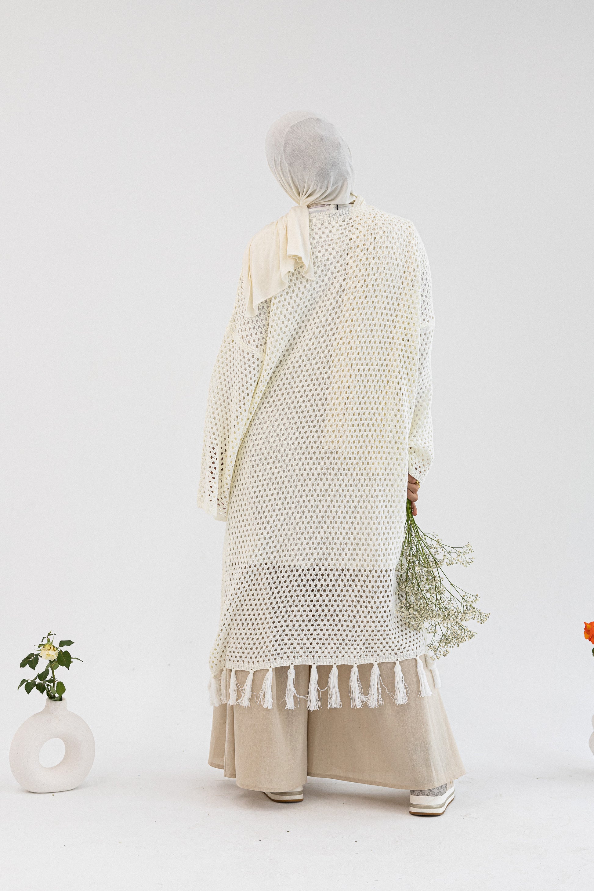 Crochet knit cardigan by Amenaa featuring a textured, cozy design in soft, neutral tones.