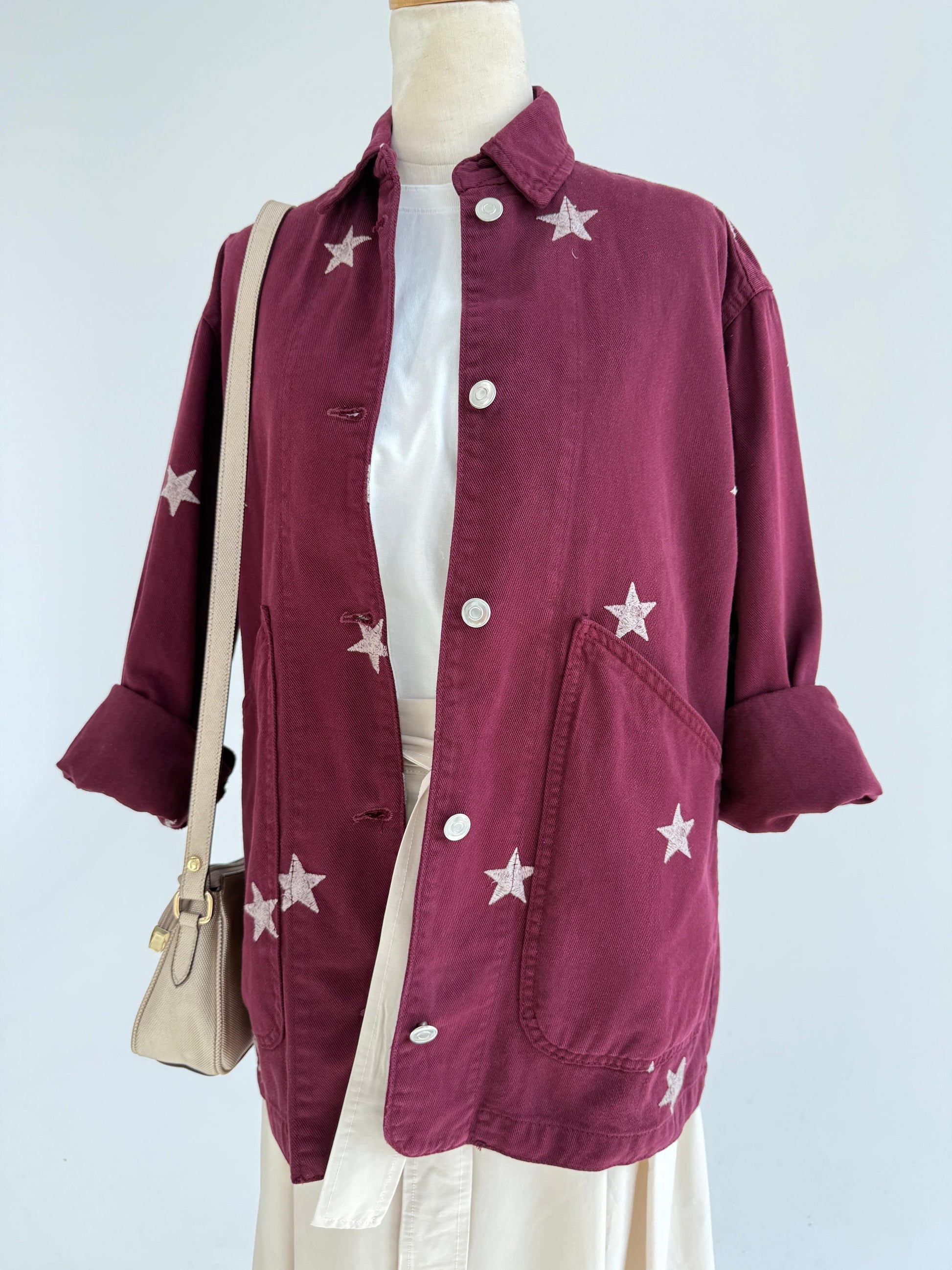 Amenaa Star Gabardine Jacket shown in black with a classic collar and button closure, featuring a stylish star pattern design.